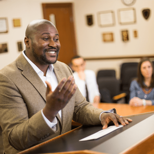 A man presents at at lectern